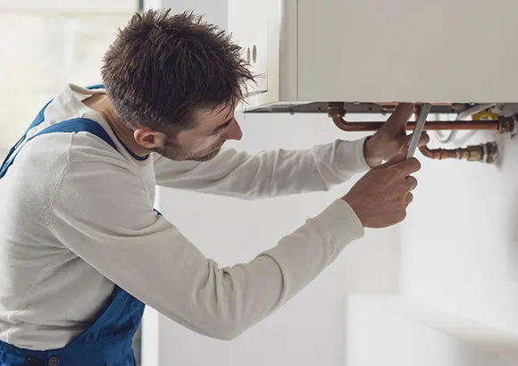 Technician installing or fixing a heating system, showcasing expert fixtures in Gainesville, FL.