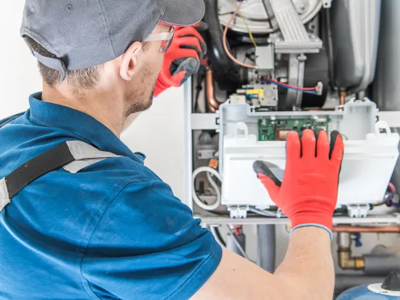 Technician working on a heating system, showcasing trusted repair services.